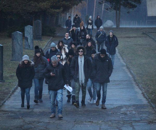 קבוצת תלמידים צועדים בבית קברות בפולין
