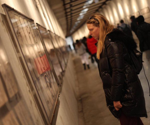 תלמידה במוזיאון מסתכלת על מוצג במסע לפולין